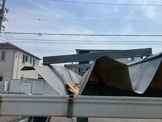 車両がぶつかって変形した折板屋根